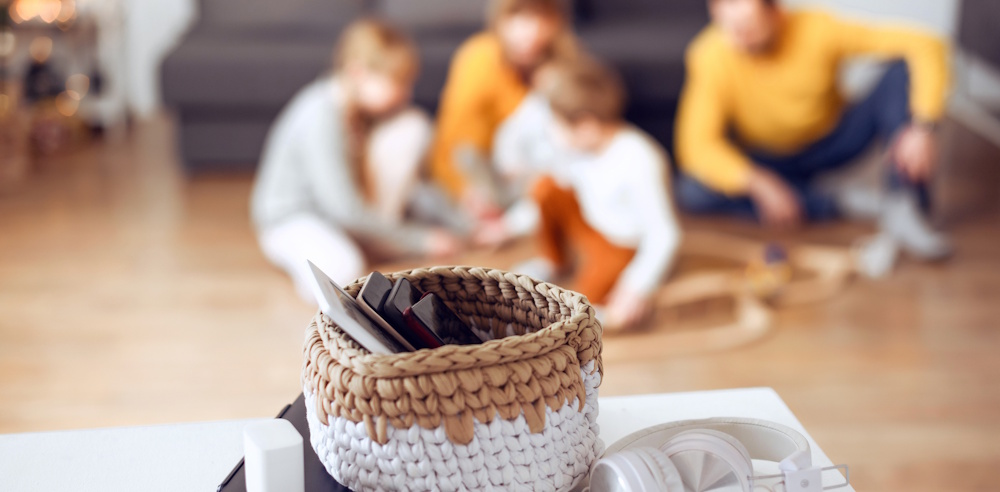 family putting away devices and playing together