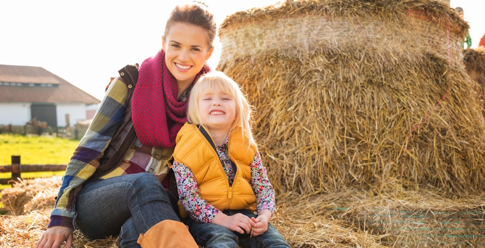 mom and daughter by hay bales